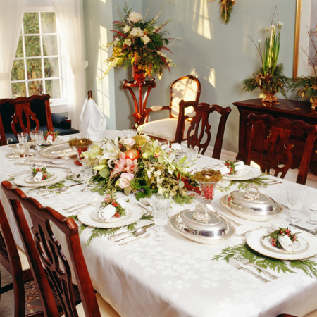 a table setting of fancy dishware surrounded by empty chairs