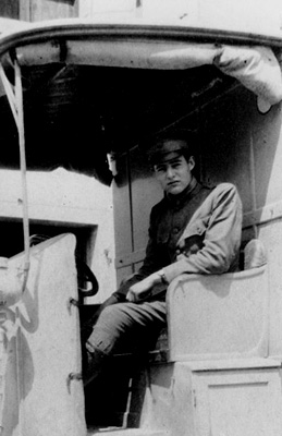 a 1918 photograph of Hemingway in uniform seated inside an open vehicle