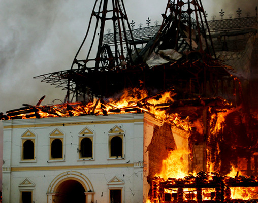 view of a building being consumed by a large fire