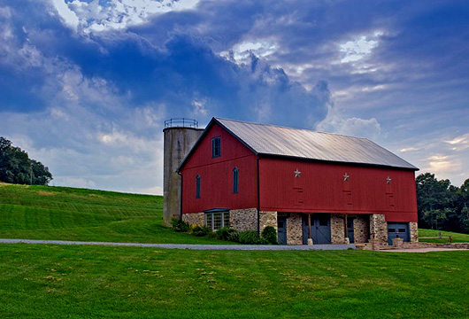 a red barn on a grassy hill